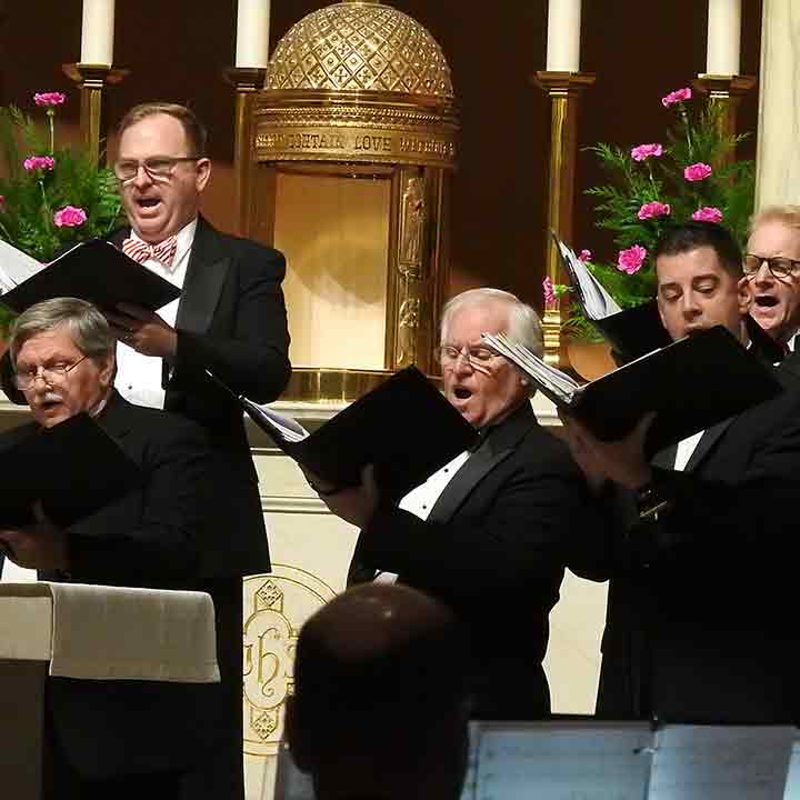 Choir singing in front of Sacred Heart altar